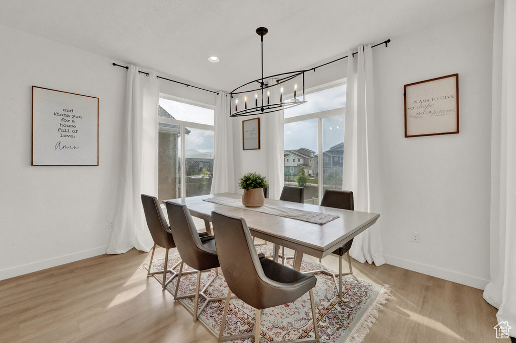 Dining room with a chandelier, light wood finished floors, and baseboards