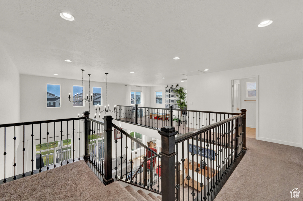 Hall with carpet floors, a chandelier, recessed lighting, an upstairs landing, and baseboards