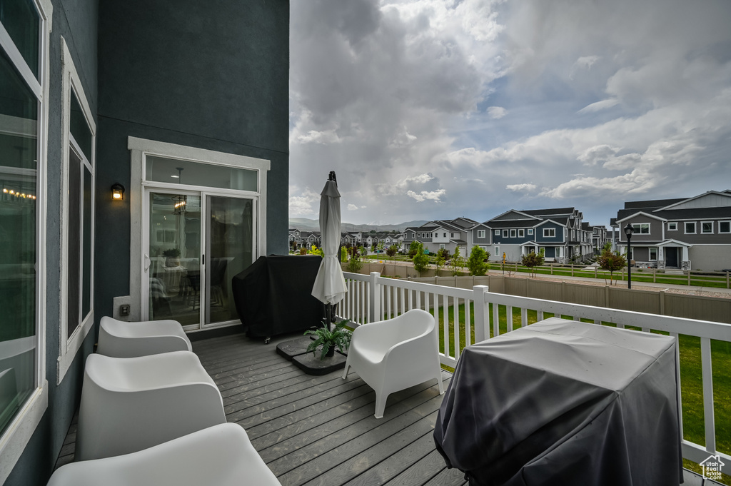 Wooden terrace featuring a residential view, grilling area, and fence