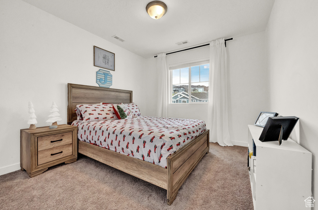 Bedroom with light colored carpet and baseboards
