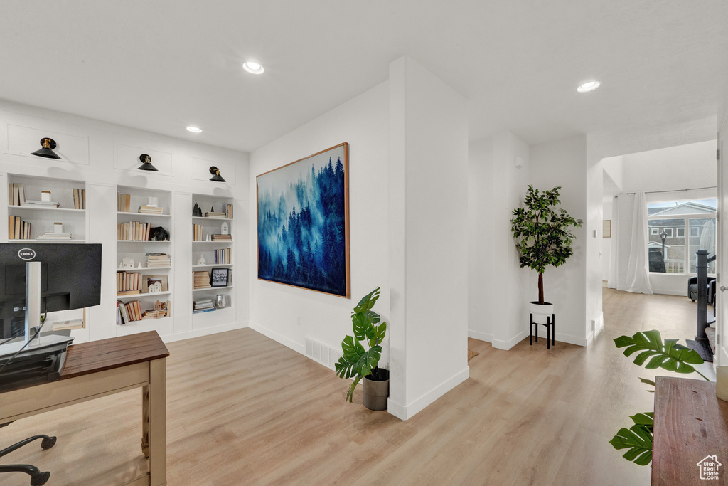 Office area with light wood-style flooring, baseboards, recessed lighting, and built in features