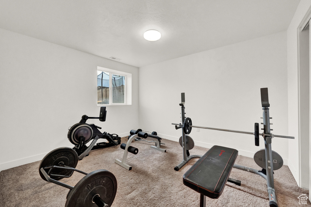 Exercise area with carpet flooring and baseboards