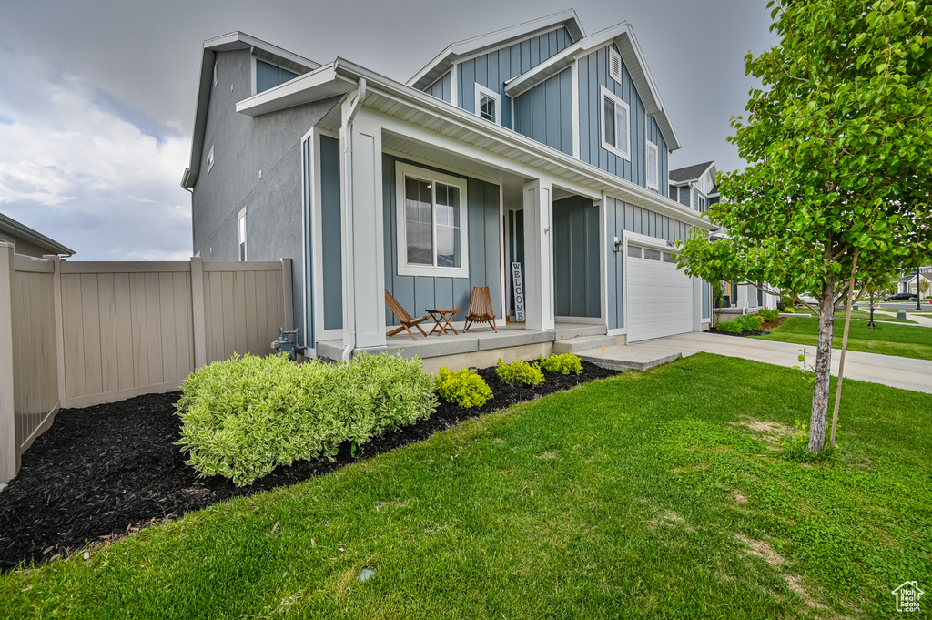 View of front of house featuring board and batten siding, covered porch, concrete driveway, and an attached garage