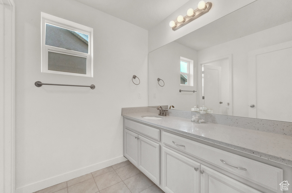 Bathroom featuring tile patterned flooring, vanity, and baseboards