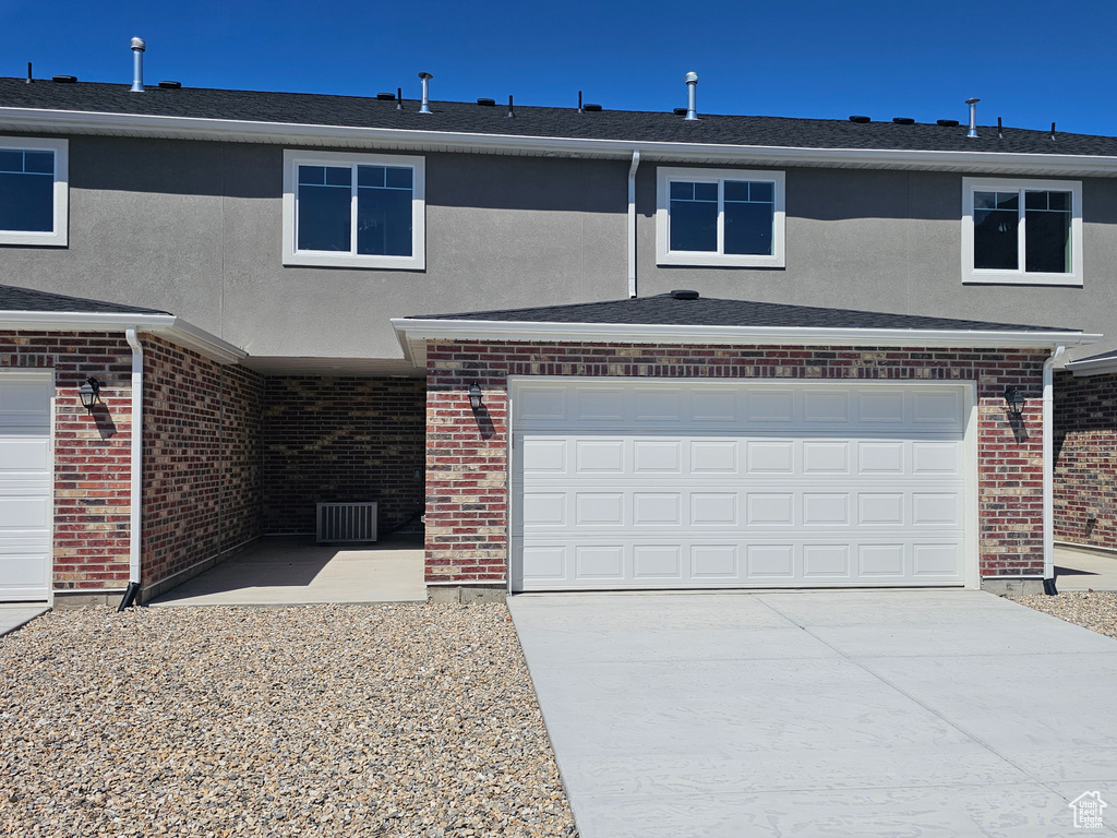 View of front of house with driveway and brick siding