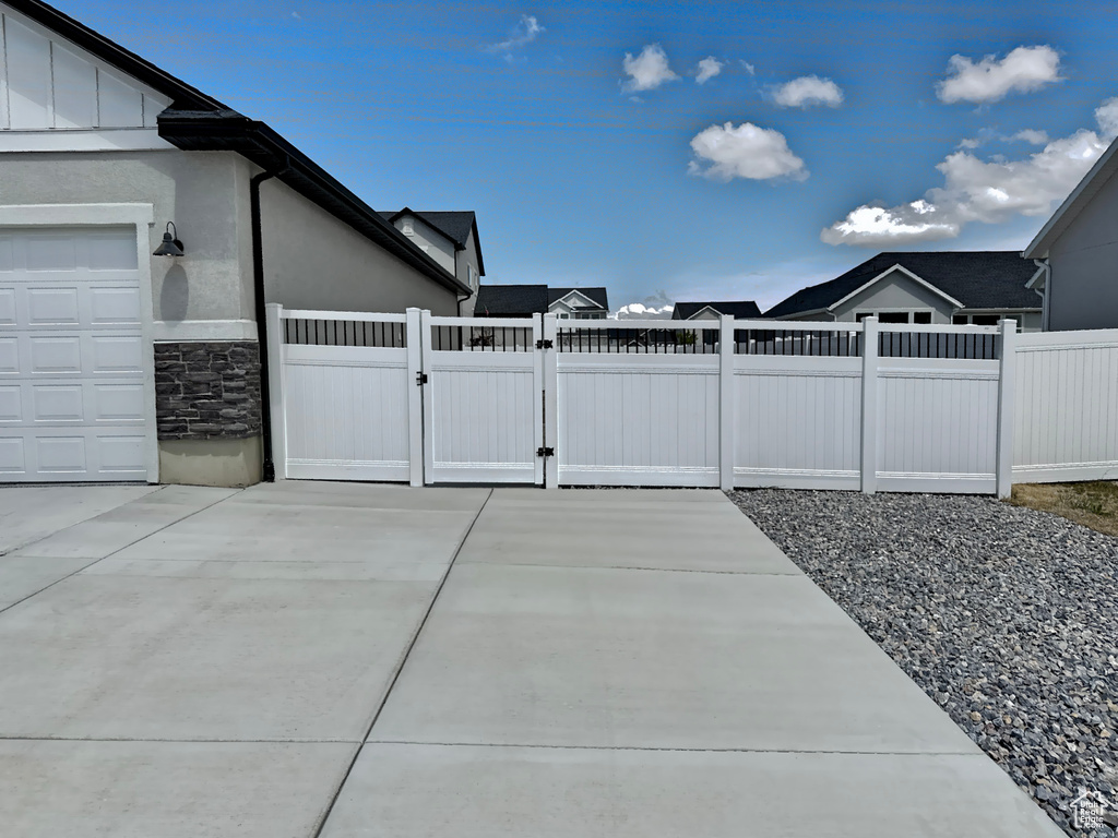 View of patio / terrace with fence, a gate, and a garage