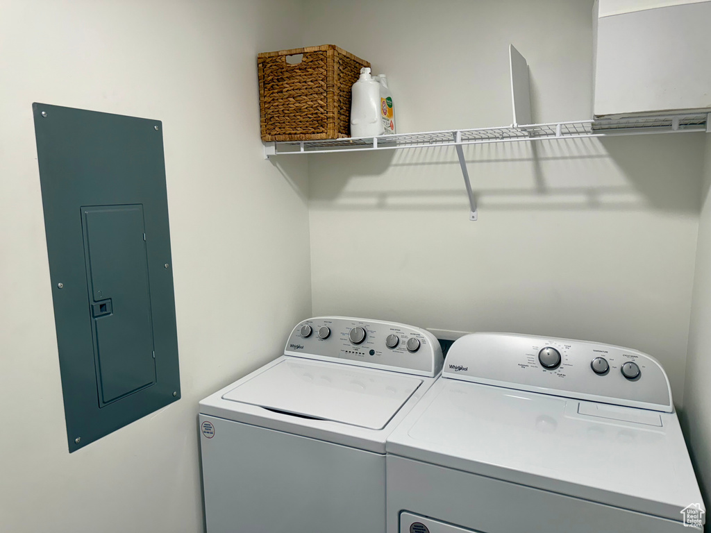 Laundry area featuring electric panel and washer and clothes dryer