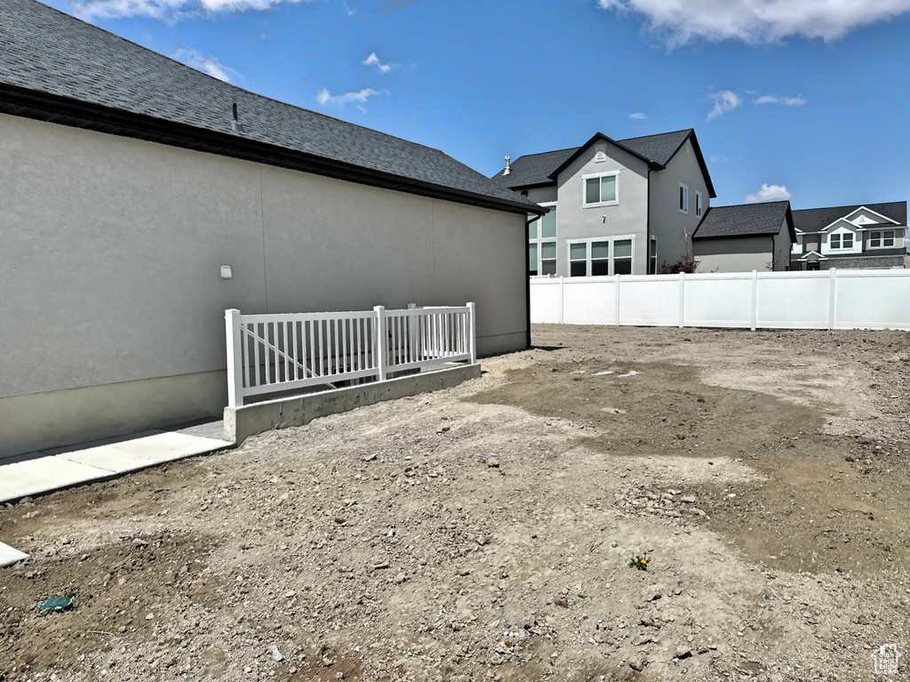 View of side of property with fence and stucco siding