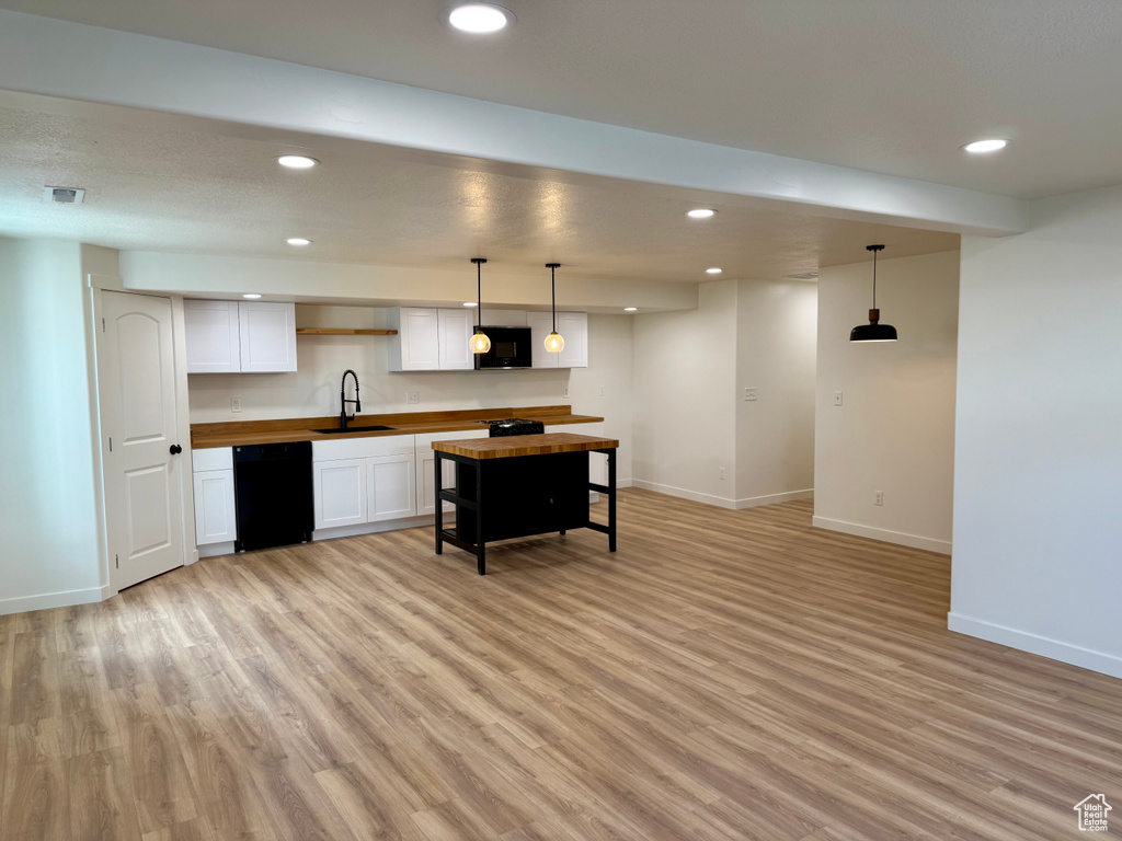 Kitchen with black appliances, wooden counters, baseboards, recessed lighting, and light wood finished floors