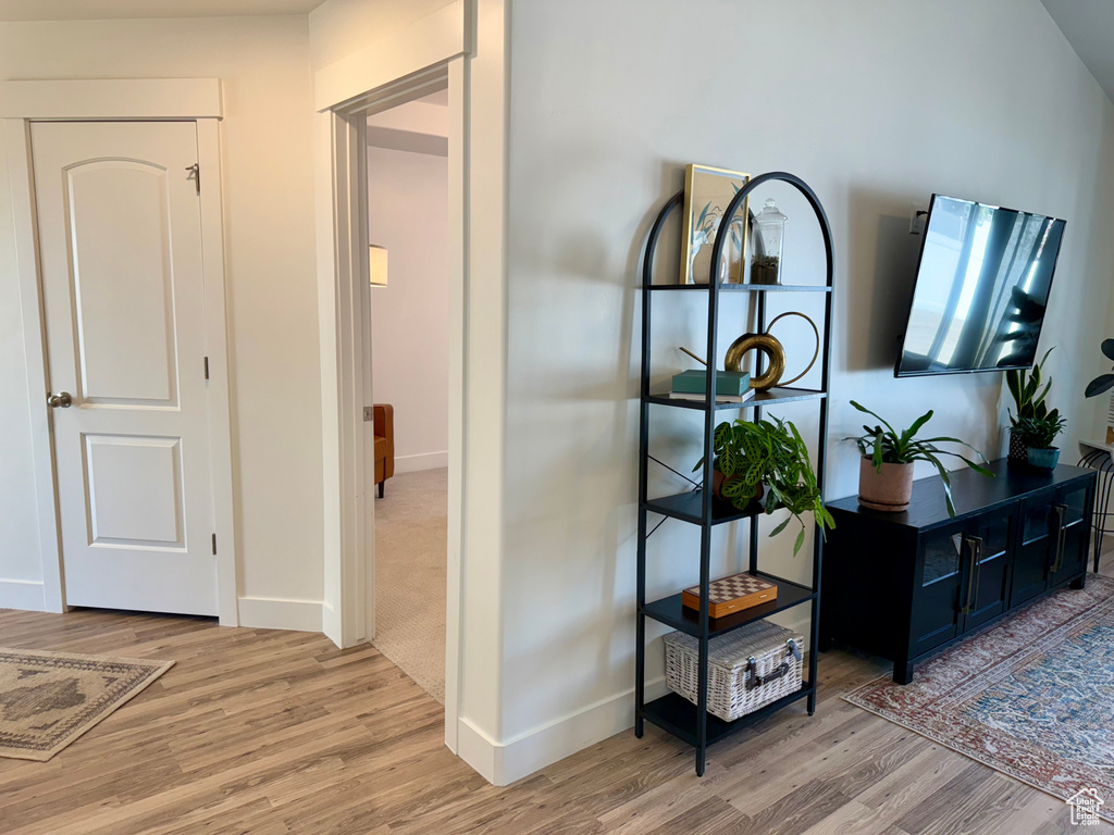 Corridor with light wood-type flooring and baseboards