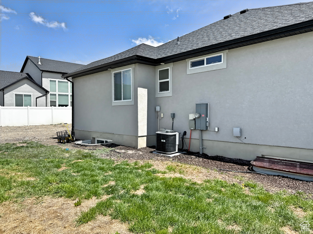 Back of property with central AC unit and stucco siding