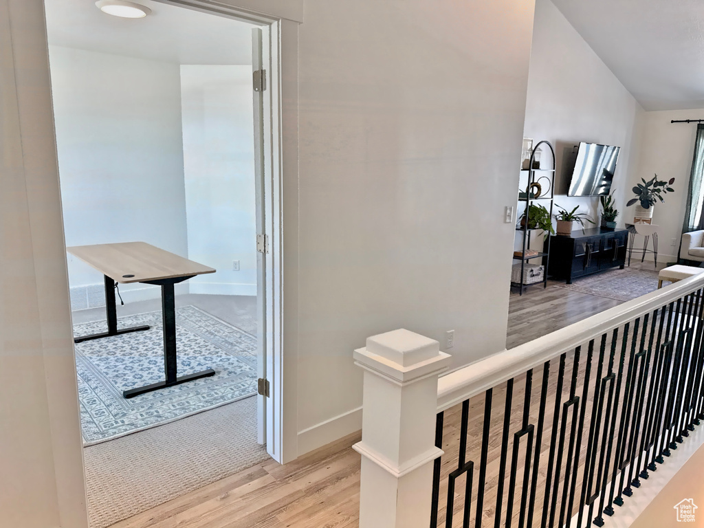 Corridor with wood finished floors, an upstairs landing, and baseboards