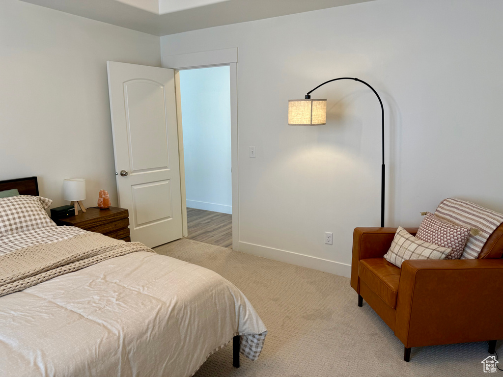 Bedroom with light colored carpet and baseboards