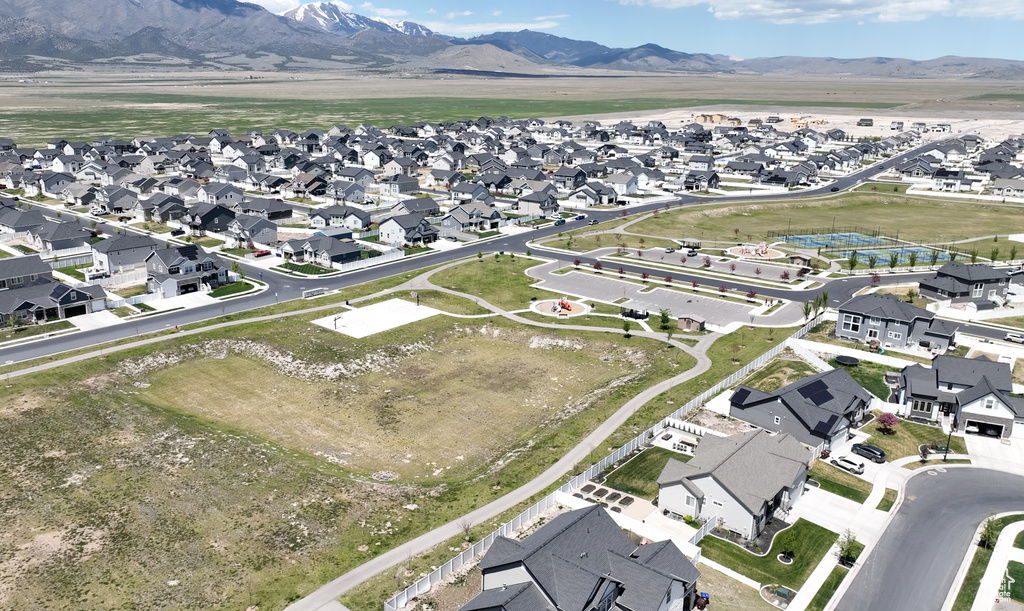 Aerial view of property and surrounding area featuring nearby suburban area and mountains
