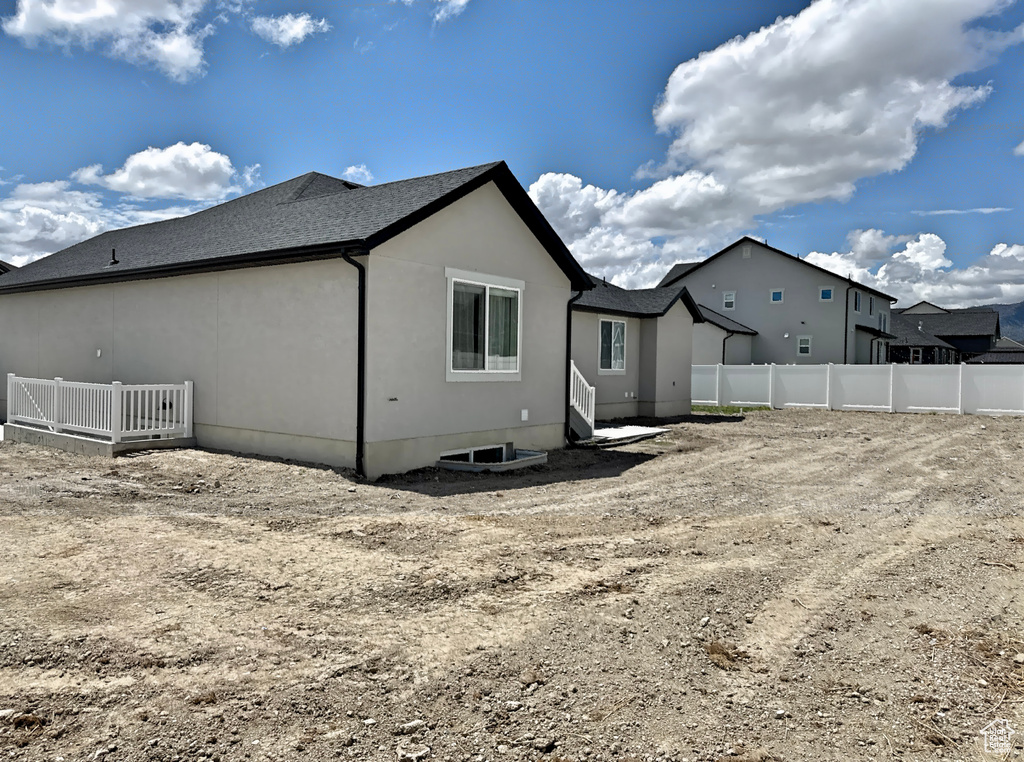 Back of house with fence and stucco siding