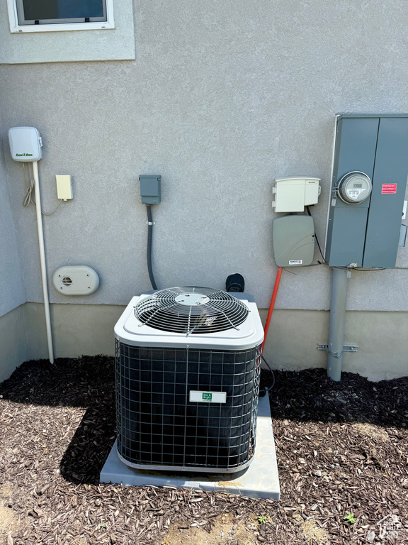 Exterior view of central AC, electric meter, and stucco siding