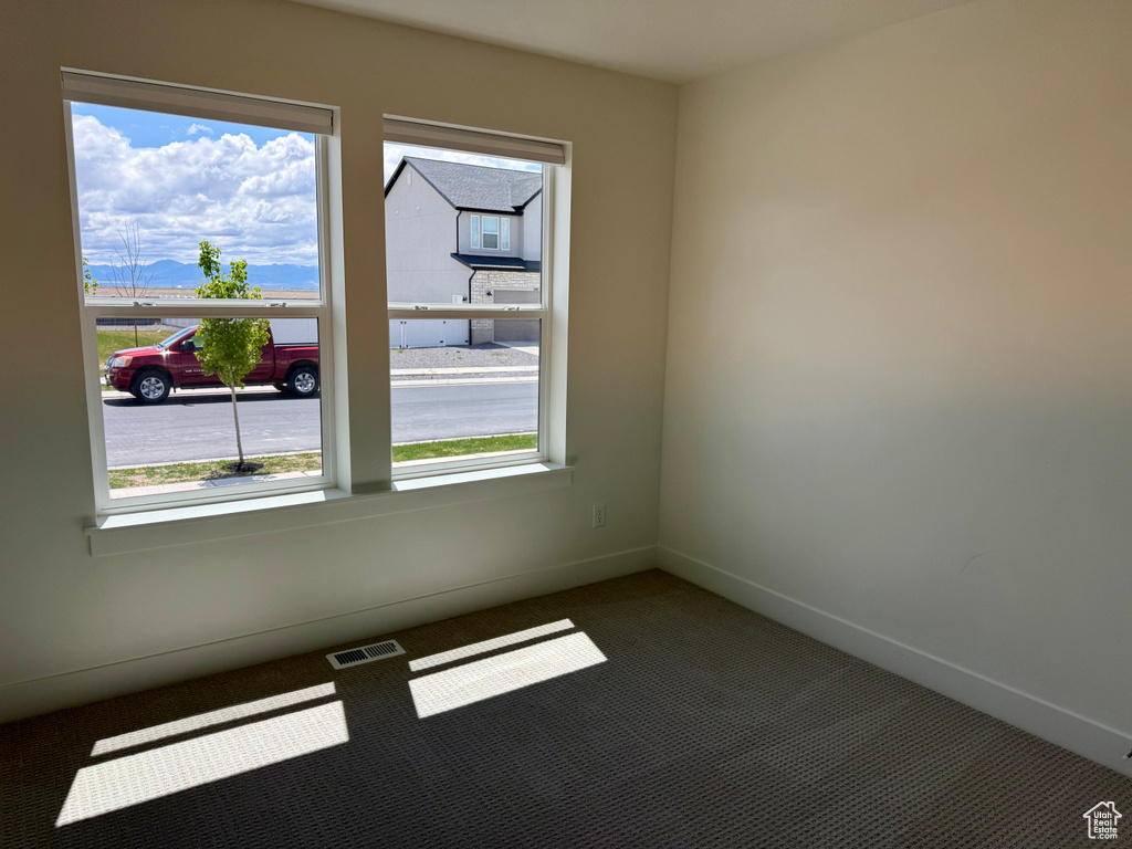 Empty room with carpet floors and baseboards