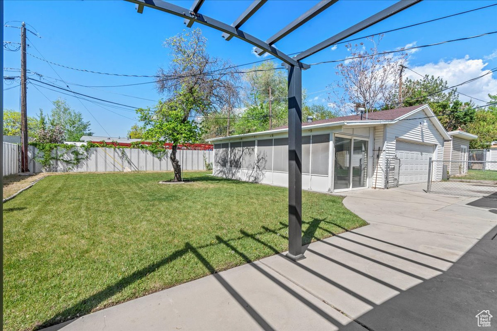 View of yard with a sunroom and a detached garage