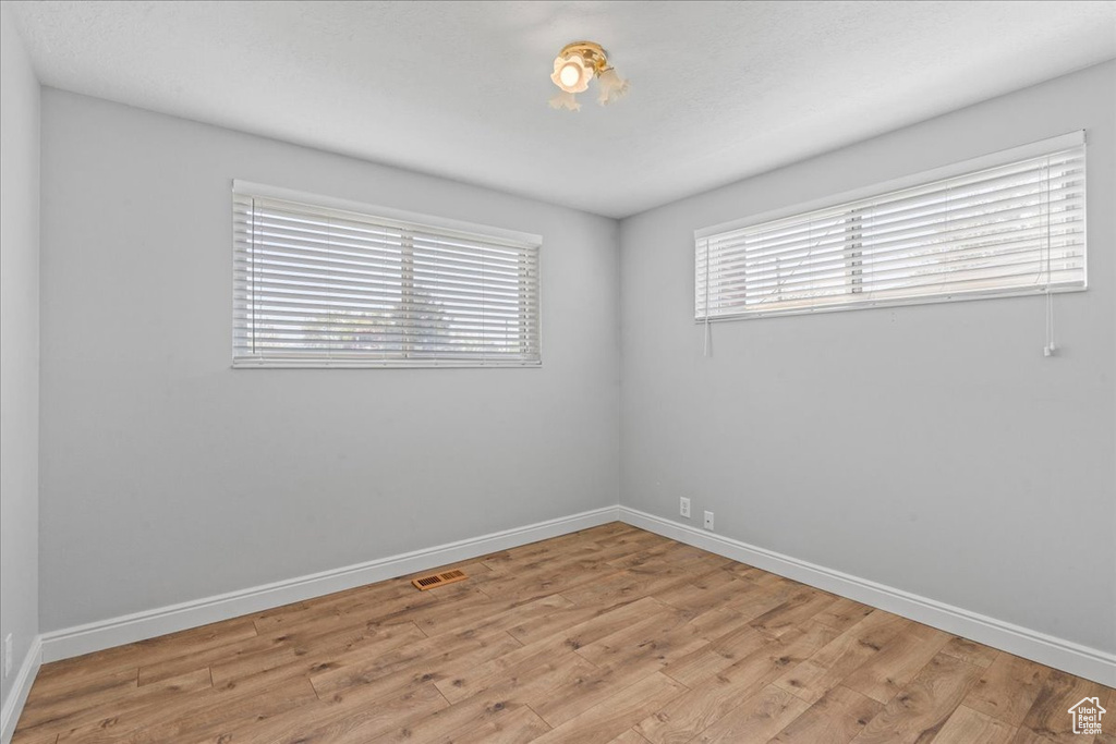 Unfurnished room with light wood-type flooring and baseboards