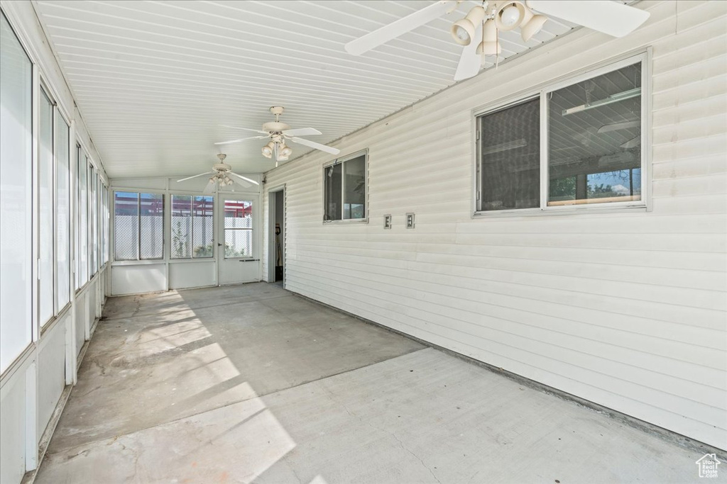 Unfurnished sunroom with a ceiling fan and lofted ceiling