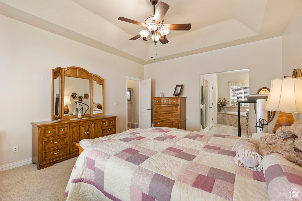 Bedroom with a ceiling fan, visible vents, a raised ceiling, baseboards, and light carpet