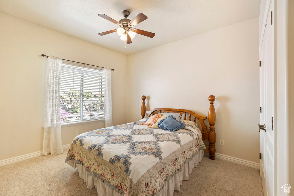 Bedroom featuring baseboards, carpet flooring, and a ceiling fan