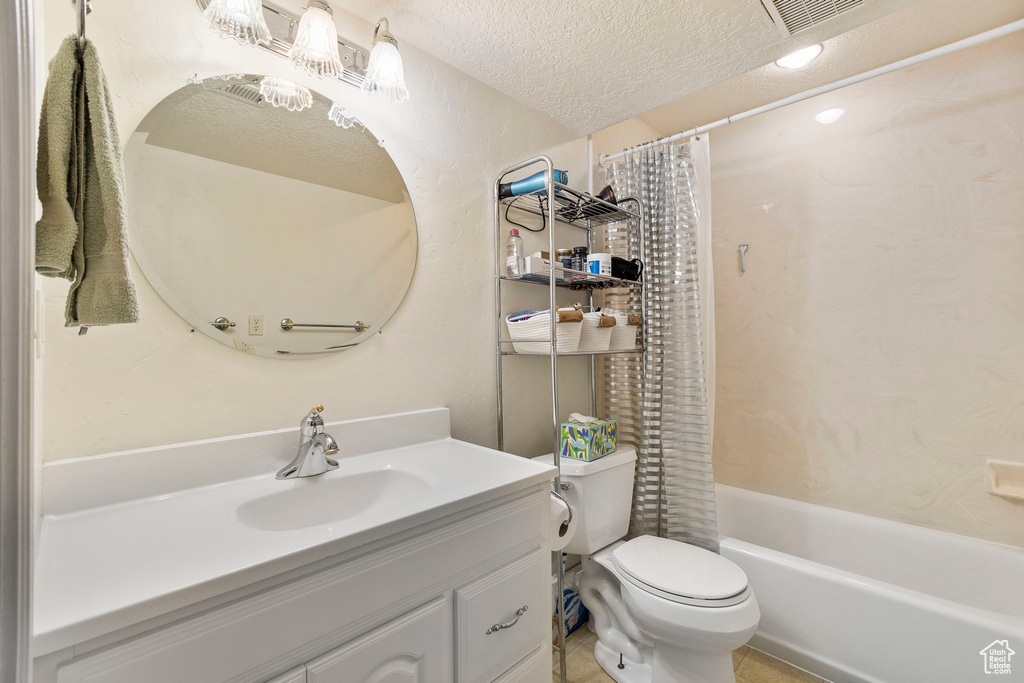 Bathroom with visible vents, vanity, shower / bath combination with curtain, toilet, and a textured ceiling