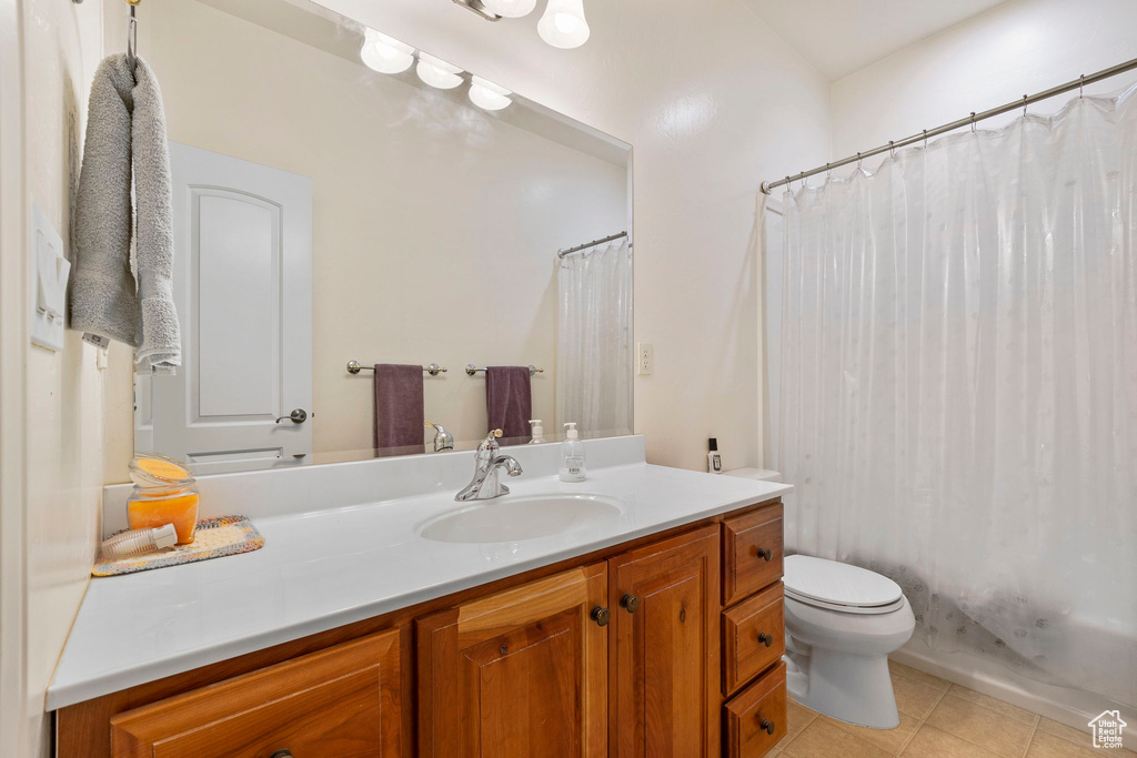 Full bath with toilet, tile patterned floors, a shower with shower curtain, and vanity