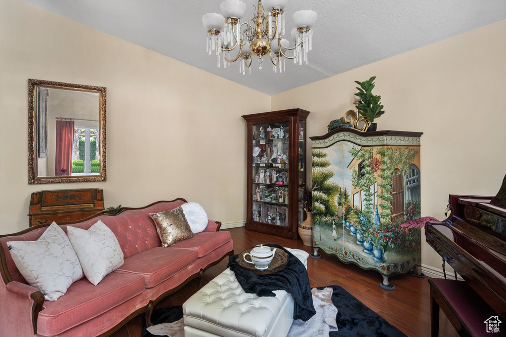 Living room featuring a chandelier, baseboards, and wood finished floors