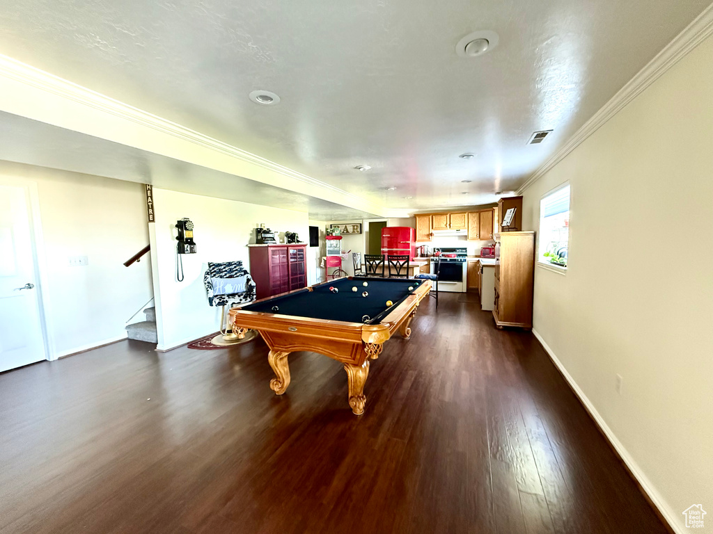 Game room with pool table, dark wood-style floors, crown molding, and baseboards