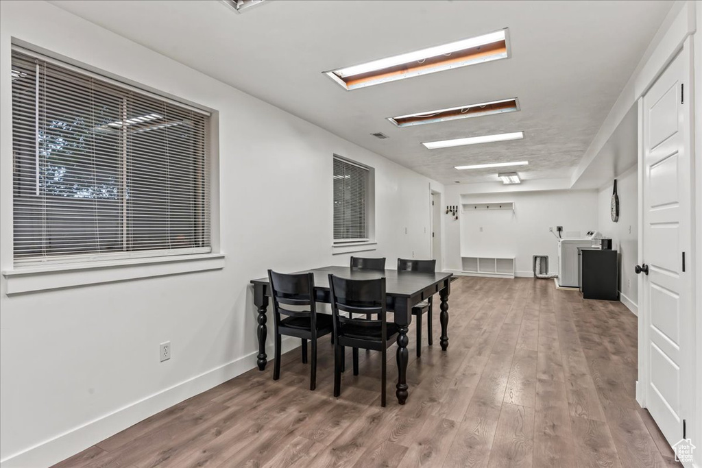 Dining room featuring wood finished floors, baseboards, and washer / dryer