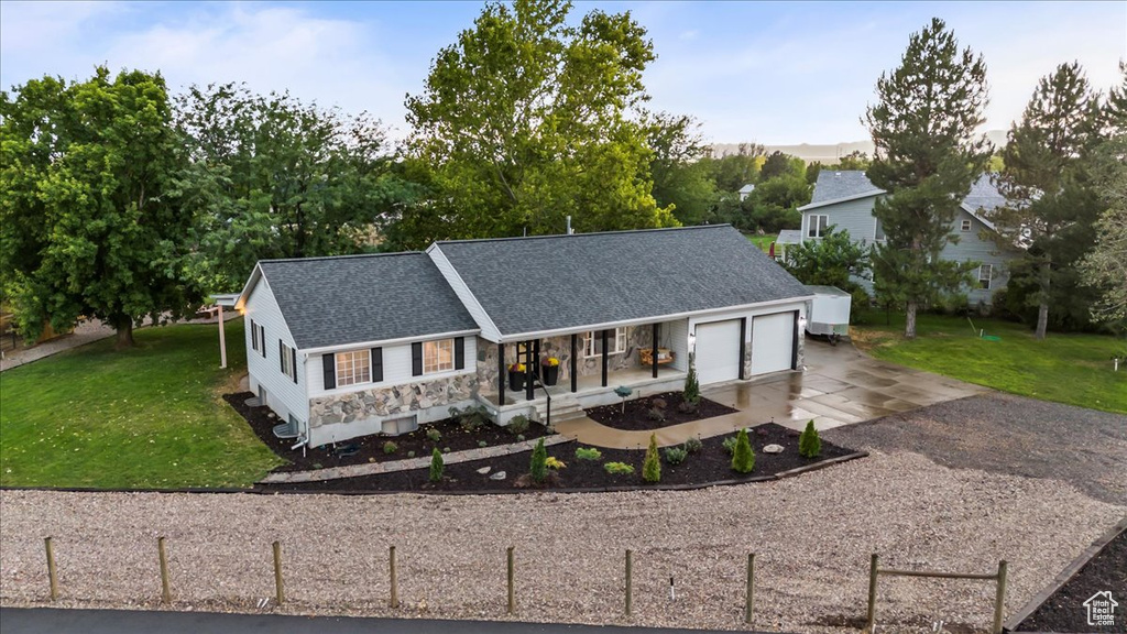 View of front facade with driveway, an attached garage, a porch, and roof with shingles