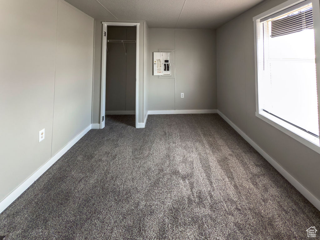 Unfurnished bedroom with carpet floors, baseboards, multiple windows, and a closet