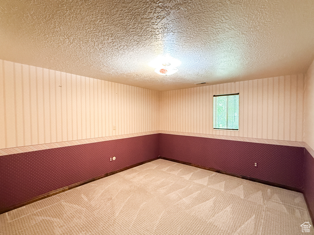 Spare room with a textured ceiling and carpet