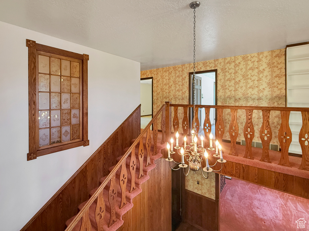 Hall with a chandelier and wallpapered walls