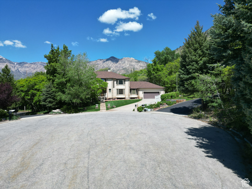 View of front of home with a mountain view, a garage, and concrete driveway
