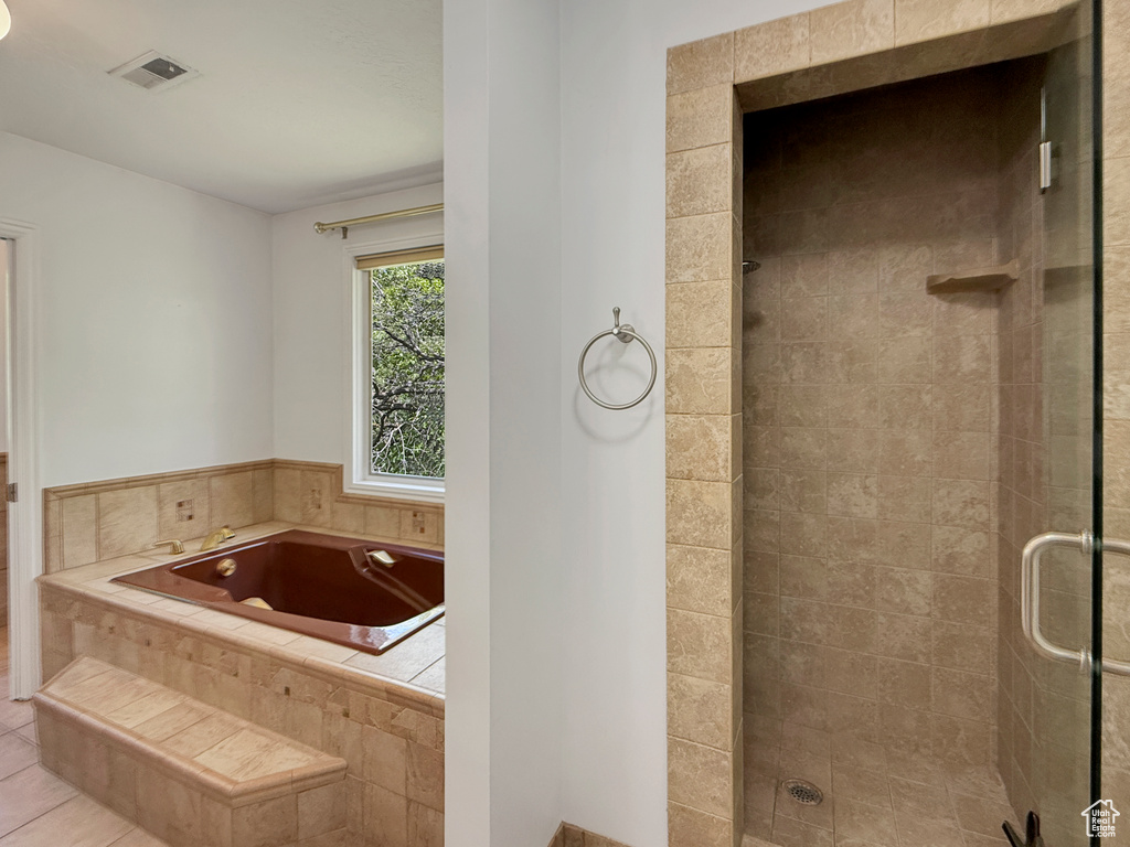 Full bathroom featuring a stall shower, a bath, and tile patterned floors
