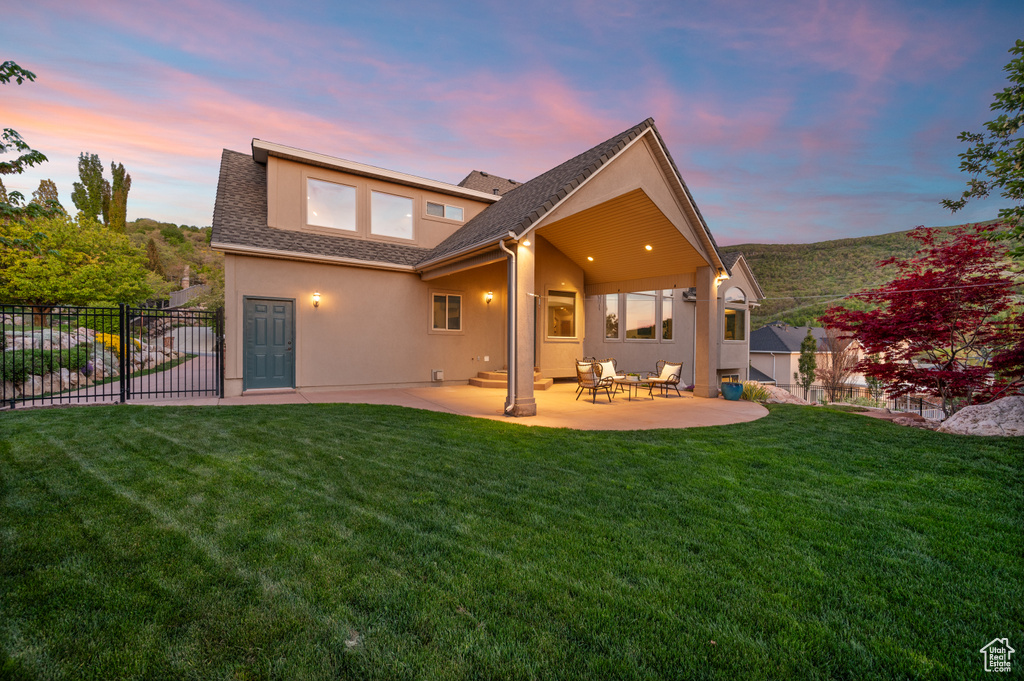 Rear view of house featuring a patio area, stucco siding, and a shingled roof