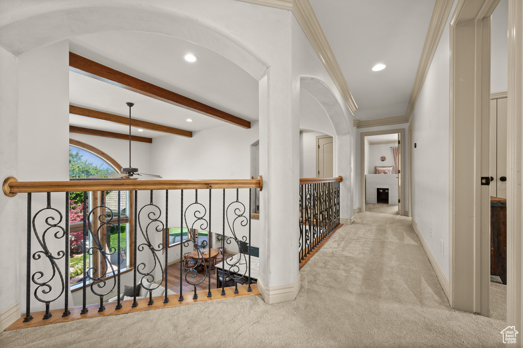 Hallway with carpet flooring, recessed lighting, arched walkways, baseboards, and beam ceiling