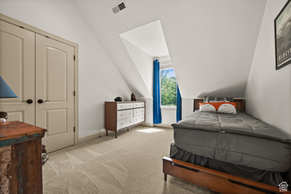 Carpeted bedroom featuring lofted ceiling and baseboards
