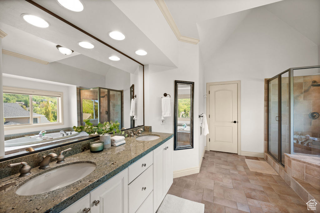 Full bath featuring a shower stall, baseboards, stone finish flooring, double vanity, and recessed lighting