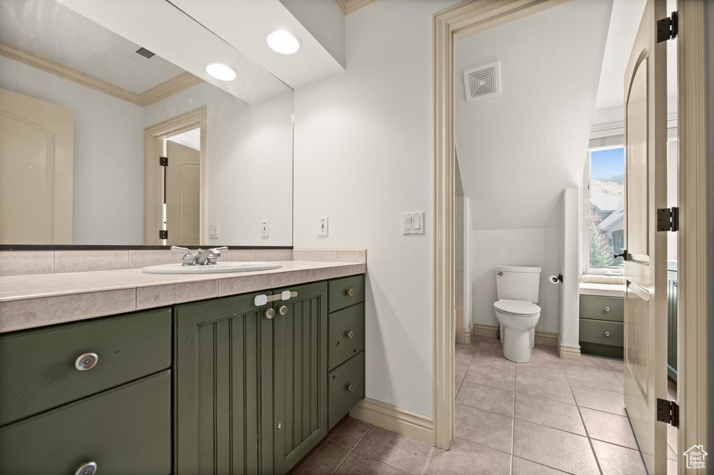 Bathroom featuring vanity, baseboards, ornamental molding, toilet, and tile patterned floors