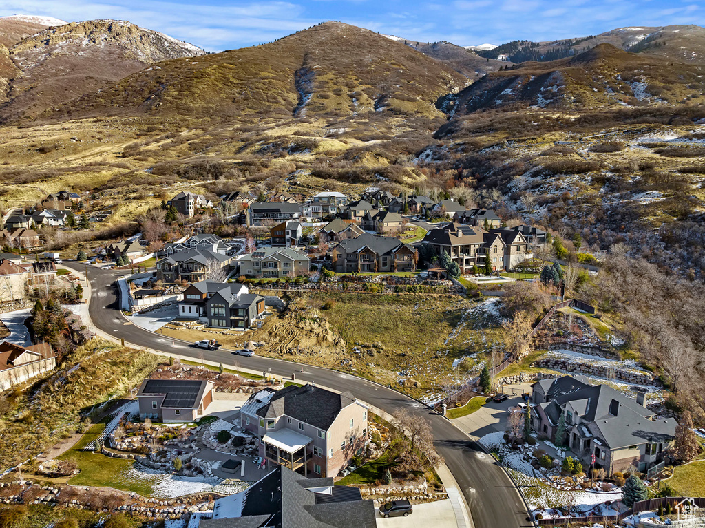 Aerial view of property and surrounding area with nearby suburban area and a mountainous background