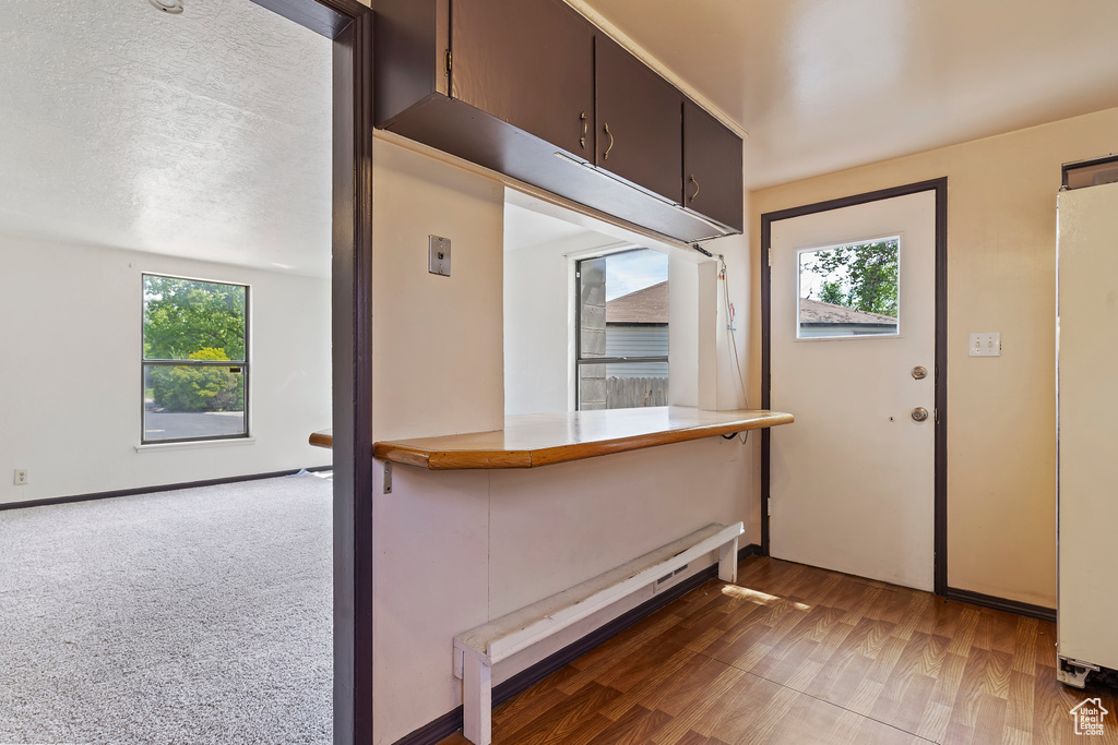 Kitchen with plenty of natural light, wood finished floors, and refrigerator