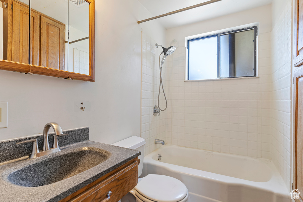 Bathroom with toilet, shower / bath combination, and vanity