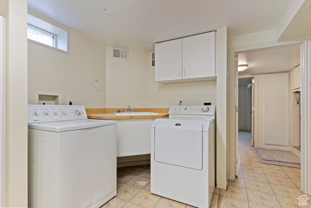 Washroom featuring cabinet space and washer and dryer