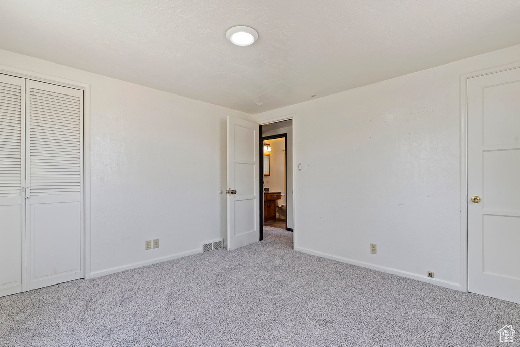 Unfurnished bedroom with carpet floors, baseboards, and a closet