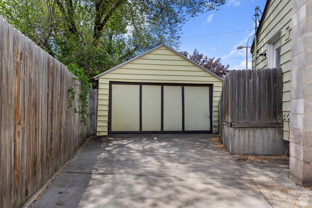 Detached garage featuring driveway and fence