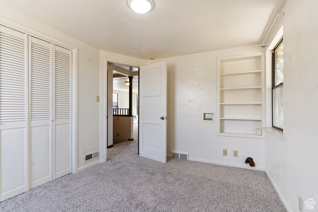 Unfurnished bedroom featuring carpet flooring, baseboards, and a closet