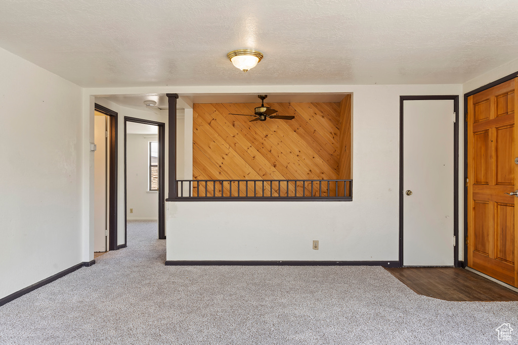 Carpeted spare room with baseboards and ceiling fan